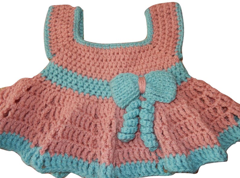 K&ouml;nnte beinhalten: Ein rosa-blaues geh&auml;keltes Babykleid mit einer Schleife an der Taille.