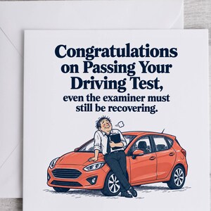 May include: A square greeting card with a white envelope featuring a cartoon of a person leaning against an orange car. The text reads: Congratulations on Passing Your Driving Test, even the examiner must still be recovering. The design is in dark blue.