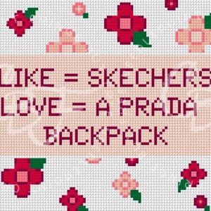 May include: A cross-stitch pattern featuring a light pink rectangular center with the dark purple text LIKE = SKECHERS LOVE = A PRADA BACKPACK. The design is surrounded by a border of pixelated red and light pink flowers with green leaves.