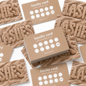 Könnte beinhalten: Eine Sammlung rechteckiger Treuekarten und Karten mit dem Wort LASHES in einer erhabenen, strukturierten, beigefarbenen Schrift. Die Treuekarten sind hellbraun mit weißem Text, der loyalty card, your 10th lash service is 50% und zehn weiße Kreise zeigt.