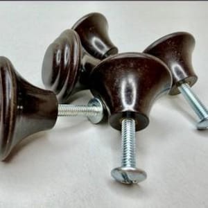 May include: A set of four dark brown cabinet knobs with a smooth, glossy finish and a tiered, circular design. Each knob features a silver-toned metal screw extending from the base, designed for attachment to furniture or cabinetry doors.