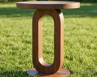 May include: A brown wooden side table featuring a circular top and a base with a central vertical oval cutout. The table has a smooth finish and a solid construction, standing upright with a flat circular bottom piece for stability and support.