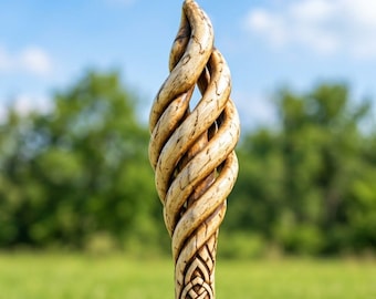May include: A light brown wooden staff featuring a carved spiral flame-like top section with visible wood grain and texture. The lower portion of the visible handle displays an intricate, symmetrical knotwork pattern carved into the wood surface.