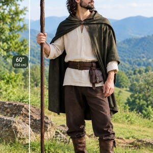 Puede incluir: Un bast&oacute;n de madera marr&oacute;n oscuro de 152 cm de altura con una parte superior retorcida, combinado con una capa con capucha de color verde oliva oscuro, una t&uacute;nica beige estilo lino, pantalones marr&oacute;n oscuro, cintur&oacute;n de cuero y botas.