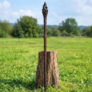 Puede incluir: Un bast&oacute;n de madera de color marr&oacute;n oscuro con un dise&ntilde;o tallado a mano en forma de jaula en espiral en la parte superior. El cuerpo del bast&oacute;n presenta un acabado texturizado similar a la corteza que recorre verticalmente su longitud.