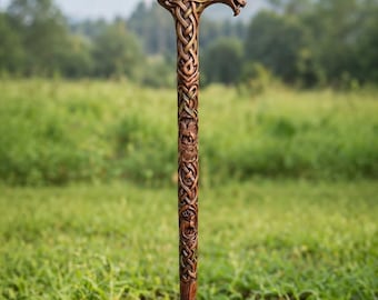 Peut inclure: Une canne de marche en bois brun ornée de motifs complexes de nœuds celtiques sculptés à la main sur toute la tige. La poignée est façonnée en forme de tête d'animal stylisée et la base est dotée d'un embout en caoutchouc noir.