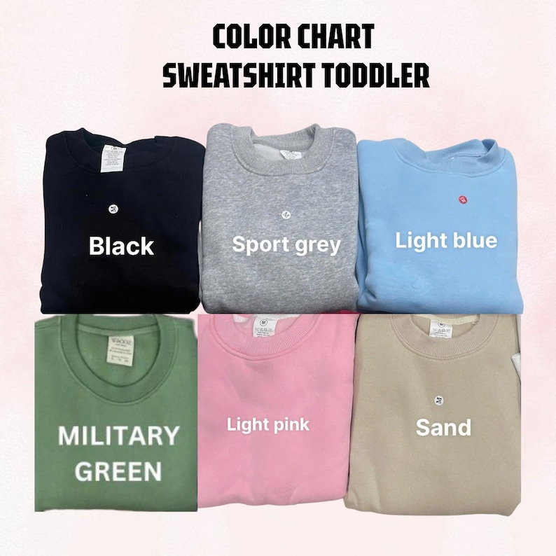 May include: A color chart for toddler sweatshirts featuring six crewneck pullovers in black, sport grey, light blue, military green, light pink, and sand. The text reads COLOR CHART SWEATSHIRT TODDLER, with labels for each color displayed on the garments.