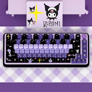 May include: A mechanical keyboard with a black frame and purple accents, featuring custom keycaps with Kuromi character graphics, a checkered pattern on the central keys, and a matching rectangular desk mat with the text KUROMI printed on it.