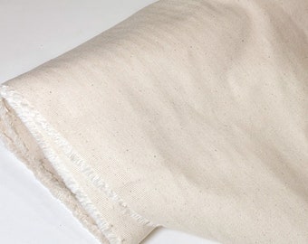 May include: A close-up of a natural-colored fabric with a slightly rough texture. The fabric is folded and has a raw edge.