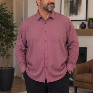 May include: A long-sleeve button-down shirt in a solid dusty rose color featuring a standard collar, a single chest pocket on the left side, and matching buttons down the front placket, paired with solid black trousers.