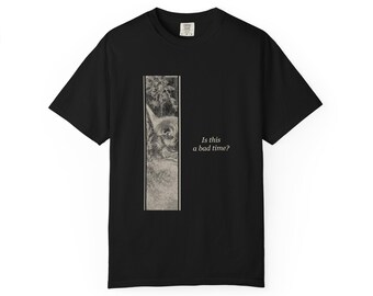 Puede incluir: Una camiseta negra de manga corta con un gráfico rectangular vertical en el lado izquierdo. El gráfico muestra una ilustración en blanco y negro de un gato asomándose. A la derecha del gráfico, el texto dice, Is this a bad time?