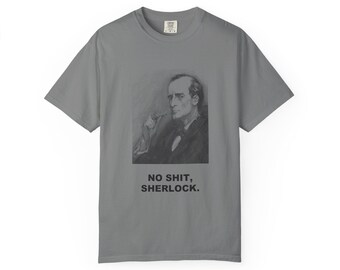 May include: A grey short-sleeve t-shirt featuring a black and white charcoal-style illustration of a man smoking a pipe. Below the illustration, the text reads in bold black capital letters: NO SHIT, SHERLOCK. The shirt has a crew neckline.