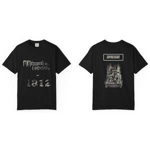 Pode incluir: Uma t-shirt preta de manga curta com um gráfico frontal que inclui o texto Hansel v. Gretel est. 1812. A parte de trás da t-shirt apresenta uma ilustração detalhada de uma casa com o texto PLEASE DO NOT EAT THE HOUSE.