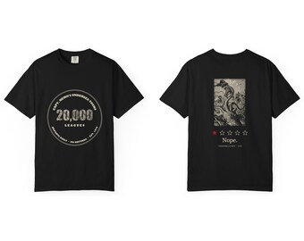 Puede incluir: Una camiseta negra de manga corta con un logotipo circular en el frente que dice Capt. Nemo's Undersea Tours 20,000 Leagues. La parte posterior muestra un gráfico de un calamar gigante atacando un barco con una estrella roja, cuatro estrellas vacías y el texto Nope.