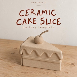May include: A light beige ceramic cake slice sculpture with a smooth, matte finish and a small cherry topper. The text CER.ATELIÉ CERAMIC CAKE SLICE pottery template PRINTABLE PDF DIGITAL DOWNLOAD is visible above and below the object.