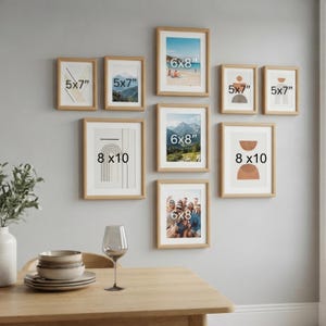 May include: A gallery wall arrangement of nine light wood picture frames in various sizes, including 13x18 cm, 15x20 cm, and 20x25 cm frames, displaying assorted abstract art prints and photographs, mounted on a plain light grey wall surface.