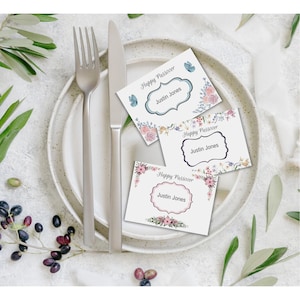 May include: Three place cards with floral designs and the text "Happy Passover" and "Justin Jones".