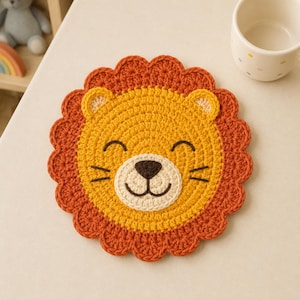 May include: A round, crocheted coaster featuring a lion face design. The center is bright yellow with a cream-colored muzzle, a dark brown nose, and stitched eyes and whiskers. It is surrounded by a scalloped, rust-orange yarn mane.