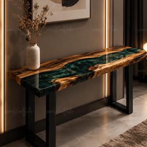 May include: A rectangular console table featuring a live edge wood slab with a central river of translucent teal epoxy resin. The table is supported by two black metal U-shaped legs and holds a white ceramic vase with dried botanical stems.