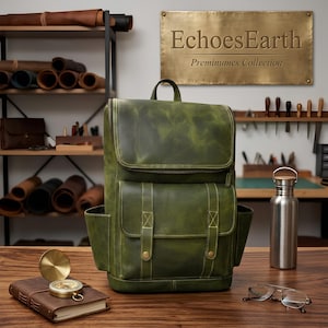 Pode incluir: Uma mochila de couro verde-floresta com aba superior, um bolso frontal com duas tiras verticais com botões de pressão cor de latão e bolsos laterais. Uma placa de metal na parede diz EchoesEarth Preminumes Collection.