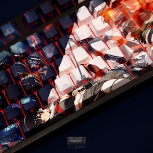 May include: A mechanical keyboard featuring custom keycaps with a split design. The left side displays dark blue cityscapes, while the right side features white keys. A long spacebar depicts an anime-style character with black hair and red eyes.
