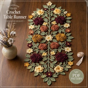 May include: A handmade crochet table runner featuring a central vine pattern with three-dimensional flowers in shades of burgundy, rust, mustard yellow, and cream, accented by green crocheted leaves. The text reads Handmade Crochet Table Runner.