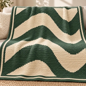 May include: A rectangular crochet blanket featuring a repeating wave pattern in dark forest green and cream yarn. The blanket is finished with a solid dark green border and a thin cream-colored edge, showcasing a consistent textured stitch.