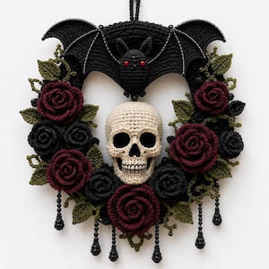 May include: A heart-shaped crochet wreath featuring a central beige skull, a black bat with red eyes at the top, and a border of dark red and black roses with olive green leaves. Black beaded fringe hangs from the bottom of the wreath.