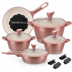 May include: A rose gold cookware set featuring a frying pan, three pots with glass lids, and four black silicone handle covers. The frying pan interior displays a black label with the white text KOCHSTELLE. All pieces have a textured exterior.