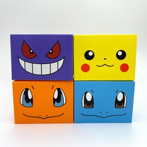 May include: Four rectangular boxes arranged in a two-by-two grid. The top left box is purple with a Gengar face, the top right is yellow with a Pikachu face, the bottom left is orange with a Charmander face, and the bottom right is blue with a Squirtle face.