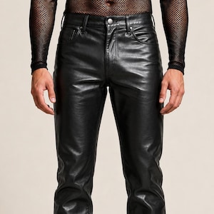 Op de afbeelding: Zwarte leren broek met een klassiek ontwerp met vijf zakken, een knoopsluiting en een rechte pijp. De broek heeft een gladde, halfglanzende afwerking en zichtbare stiksels langs de naden, zakken en tailleband voor een gestructureerde uitstraling.