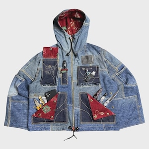 Könnte beinhalten: Eine blaue Jeansjacke mit Kapuze, Patchwork-Design, mehreren Taschen, roten gemusterten Stoffakzenten und einem Frontreißverschluss. Die Jacke enthält verschiedene Werkzeuge und Gegenstände in den Taschen, darunter ein Telefon und eine Schere.