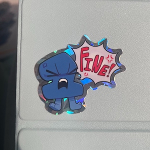 May include: A holographic sticker featuring a blue, anthropomorphic character with an angry expression. The character is depicted with a speech bubble containing the red text "FINE!" and small red star-like symbols indicating frustration.