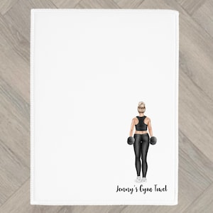 Könnte beinhalten: Weißes Gymnastiktuch mit einer genähten Bordüre. Das Handtuch zeigt eine Illustration einer Person in schwarzer Trainingskleidung, die Hanteln hält. Der Text "Jenny's Gym Towel" ist unten in schwarzer Schrift gedruckt.