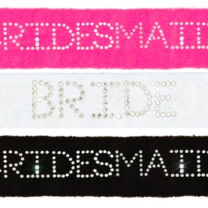 image of three personalised sweatbands for the head. one is pink, one is white and one is black. each is personalised with rhinestones to say a word such asbride or bridesmaid
