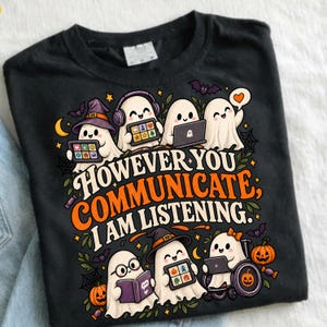 Könnte beinhalten: Ein schwarzes T-Shirt mit einer Grafik von mehreren weißen Geistern, die verschiedene Kommunikationsgeräte wie Tablets, Laptops und Bücher benutzen. Der Text lautet "HOWEVER YOU COMMUNICATE; I AM LISTENING." Das Design enthält kleine Fledermäuse und Kürbisse.