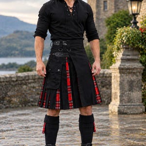 Peut inclure: Une chemise noire à manches longues avec un col lacé, un kilt noir avec des plis en tartan rouge et blanc, des poches cargo latérales et des sangles réglables, associé à des chaussettes hautes côtelées noires et des bottines noires à lacets.