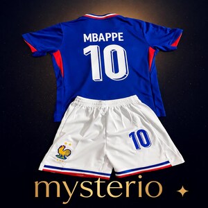 May include: A blue soccer jersey with the name MBAPPE and the number 10 in white on the back, paired with white soccer shorts featuring the number 10 in blue and a small rooster emblem on the leg, accented with red, white, and blue trim.
