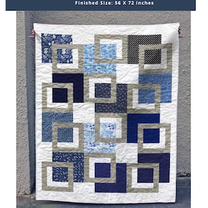May include: A quilt titled Midnight Frames with a finished size of 56 x 72 inches. The quilt features a geometric pattern of interlocking squares in shades of navy blue, light blue, white, and tan, with various floral and polka dot prints.