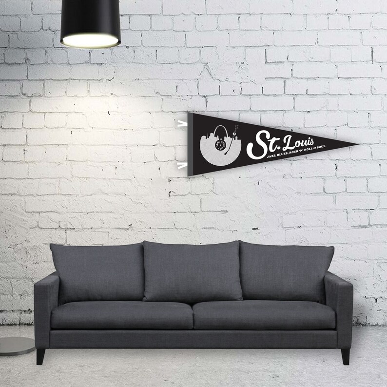 May include: Black and white pennant flag with the text "St. Louis" and the words "Jazz, Blues, Rock 'n' Roll, Soul". The flag features a stylized image of the St. Louis skyline with a record player.