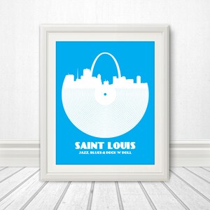 May include: A blue and white print of the St. Louis skyline with the Gateway Arch, designed to look like a vinyl record. The text below reads "Saint Louis Jazz, Blues & Rock 'n' Roll".
