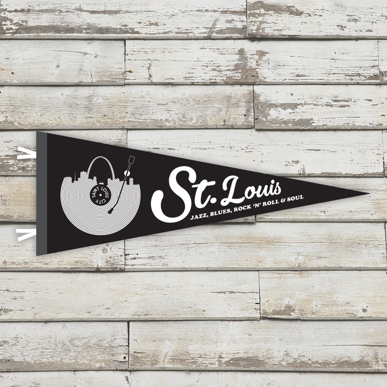 May include: Black and white pennant flag with a record design featuring the St. Louis skyline and the text "St. Louis" with the tagline "Jazz, Blues, Rock 'n' Roll & Soul".