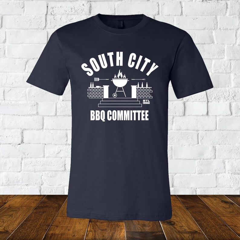 May include: A navy blue t-shirt with a white graphic of a grill, beer bottles, and the text "South City BBQ Committee".