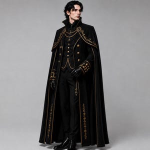 May include: A black floor-length cape featuring gold embroidery along the edges, worn over a black vest with gold buttons, a black shirt, and black trousers. The ensemble includes black gloves and a gold chain accessory draped across the chest.