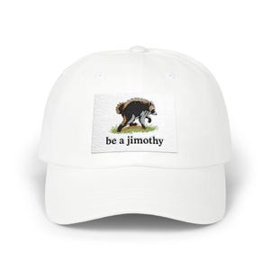 May include: A white baseball cap featuring a rectangular patch on the front. The patch displays an embroidered illustration of a raccoon walking on green grass, positioned above the black text that reads be a jimothy in a serif font.
