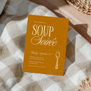 May include: A rectangular invitation card in mustard yellow with white text reading "You're invited to a SOUP Soirée", "Thursday, September 12", "7:00 pm | Mia's House", "1234 Harvest Circle, City", "Bring yourself and your favorite soup!", and "RSVP by Sept 2nd".