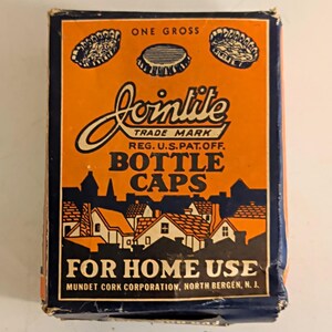 May include: A rectangular cardboard box for Jointite bottle caps with an orange and dark blue color scheme. The front features illustrations of bottle caps, a town silhouette, and text including One Gross, Bottle Caps, For Home Use, and Mundet Cork Corporation, North Bergen, N. J.