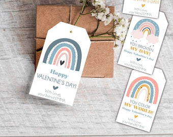 Puede incluir: Cuatro etiquetas de regalo imprimibles con un diseño de arcoíris en colores rosa, azul y amarillo. El texto en las etiquetas dice "¡Feliz Día de San Valentín!"  "¡Tú iluminas mi día!"  "¡Feliz Día de San Valentín!"  "¡Tú coloreas mi mundo!"  "¡Feliz Día de San Valentín!"  Cada etiqueta incluye la frase "Con amor, tu amigo/a EMMA".