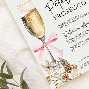 May include: A white invitation card with a watercolor illustration of a champagne flute with a pink bow. The text on the card reads "Petal Prosecco" and "Please join us for a bridal shower in honor of Rebecca Anderson" with the date, time, and location of the event.