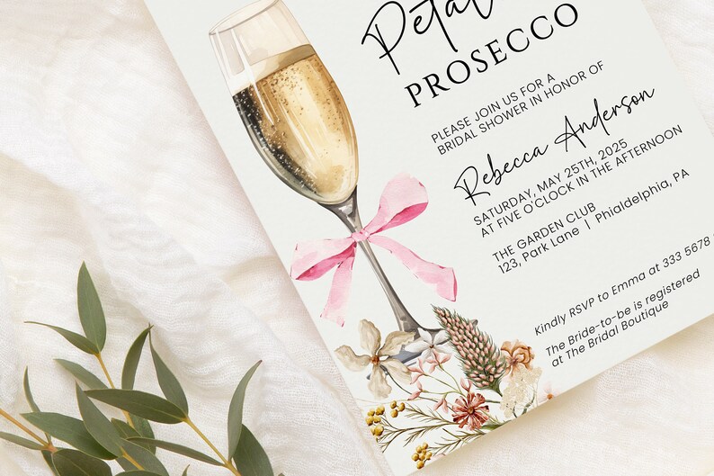 May include: A white invitation card with a watercolor illustration of a champagne flute with a pink bow. The text on the card reads "Petal Prosecco" and "Please join us for a bridal shower in honor of Rebecca Anderson" with the date, time, and location of the event.